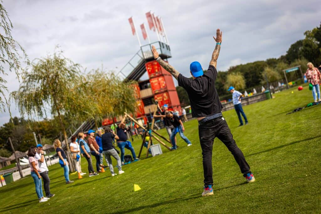 Teamlid moedigt collega's aan tijdens een teambuilding bij Beachclub Degreez in Limburg.