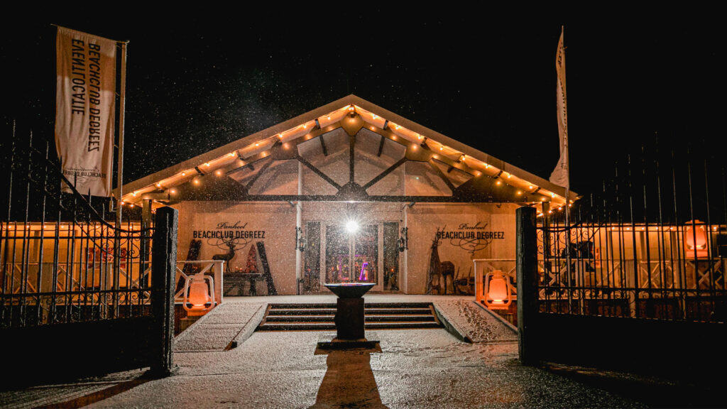 Sfeervolle verlichte entree van Beachclub Degreez in Limburg.