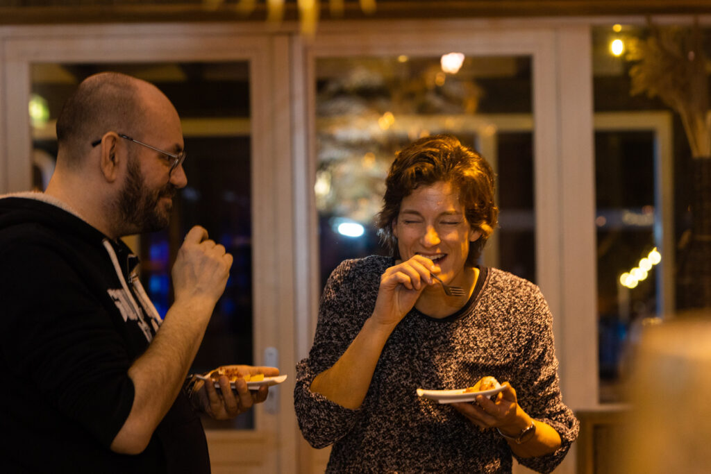 Twee gasten lachend met luxe eten op een feest bij eventlocatie Beachclub Degreez.