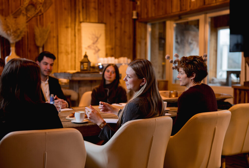 Zakelijke meeting bij Beachclub Degreez in Limburg, groep professionals in overleg in een sfeervolle vergaderruimte.