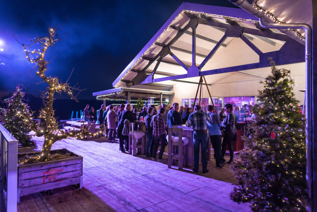 Gasten genieten van een sfeervolle kerstborrel bij Beachclub Degreez in Limburg.