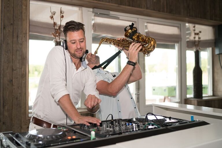 Dj en saxofonist zorgen voor livemuziek tijdens een jubileumfeest bij Beachclub Degreeez in Limburg.
