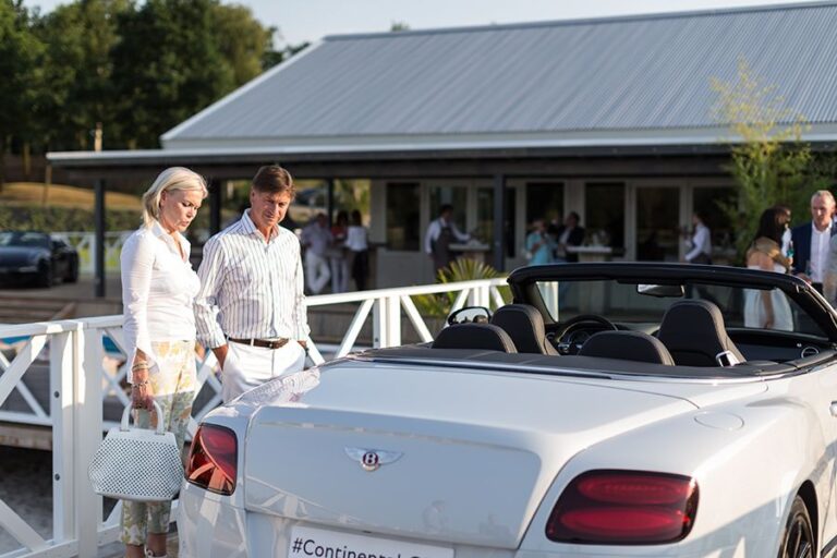 Bezoekers bekijken een luxe cabriolet tijdens een exclusieve productpresentatie bij Beachclub Degreez in Limburg.