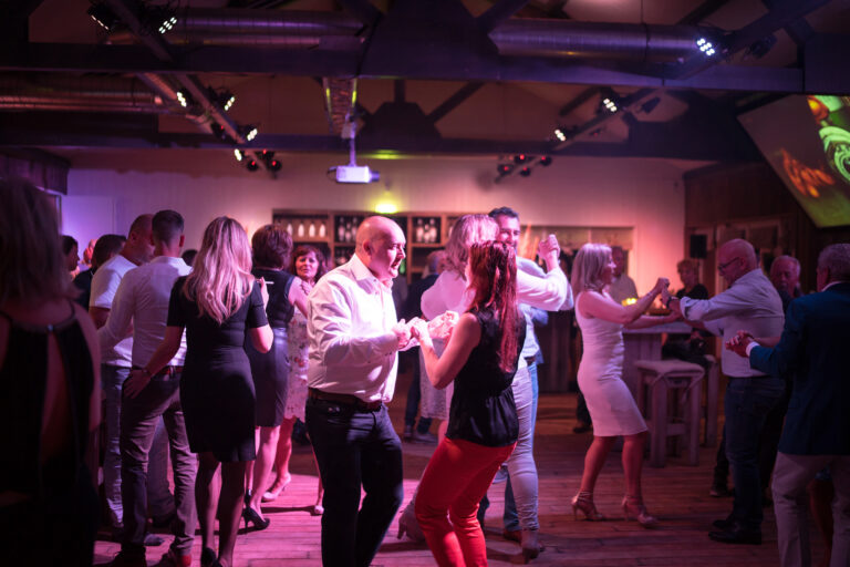 Gasten dansen samen op de dansvloer tijdens een personeelsfeest in de winter bij Beachclub Degreez in Limburg.