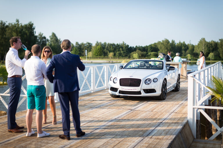 Bezoekers bekijken een luxe cabriolet op de pier bij beachclub Degreez in Limburg