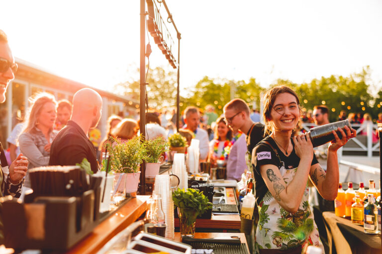 Barvrouw shaket cocktails tijdens een personeelsfeest bij Beachclub Degreez.