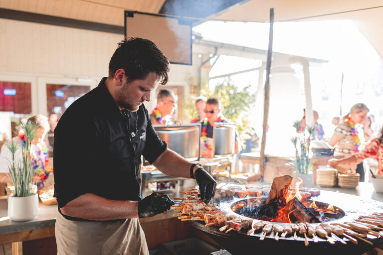 Chef bereidt spiesjes op een Ofyr barbecue tijdens een personeelsfeest bij Beachclub Degreez.