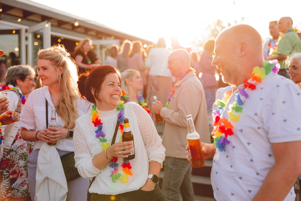 Twee mensen die vrolijk een drankje doen op een bedrijfsfestival bij Beachclub Degreez.