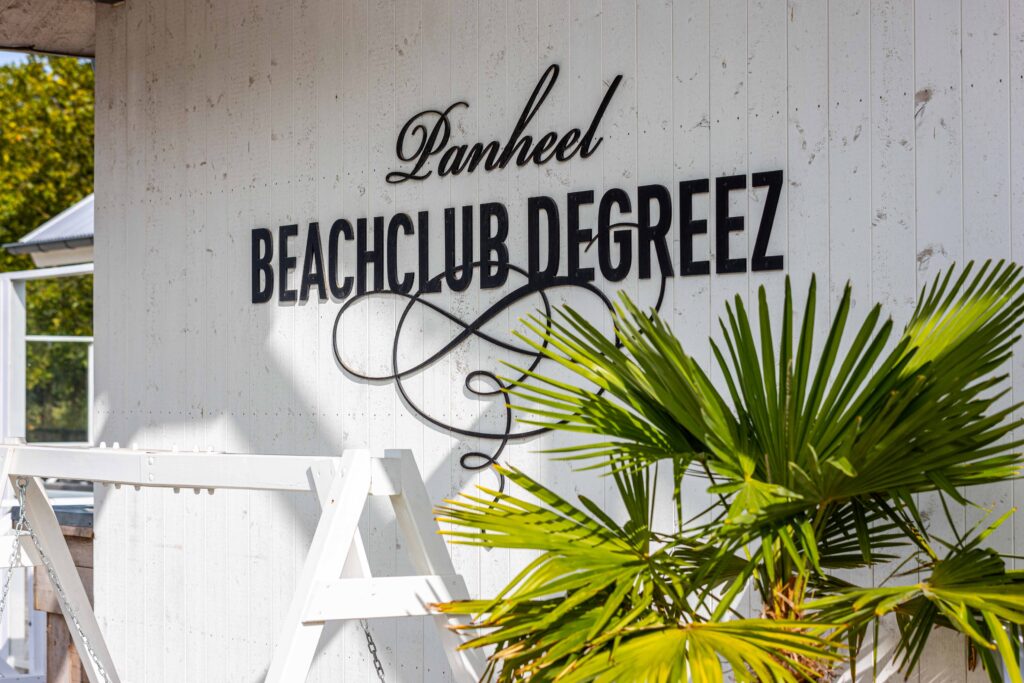 Het logo van Beachclub Degreez op de muur van de Beachclub.
