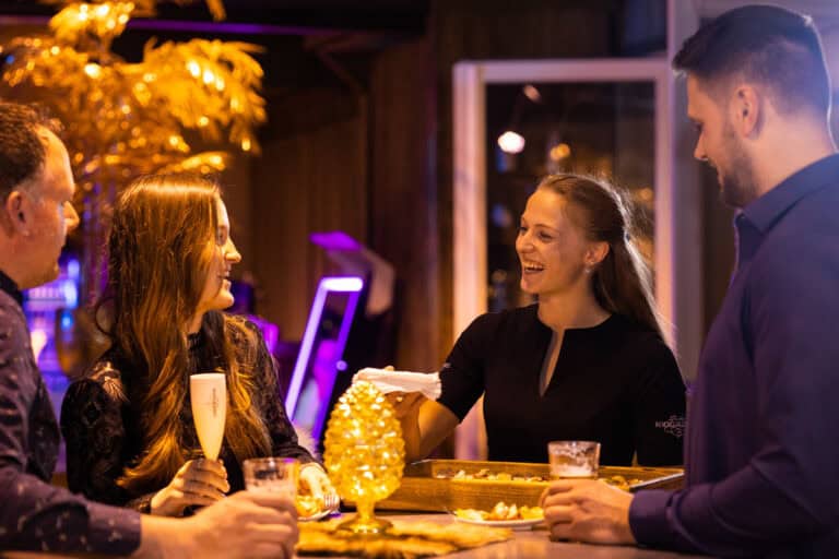 Gasten genieten van hapjes en drankjes tijdens een neiuwjaarsborrel bij Beachclub Degreez in Limburg.