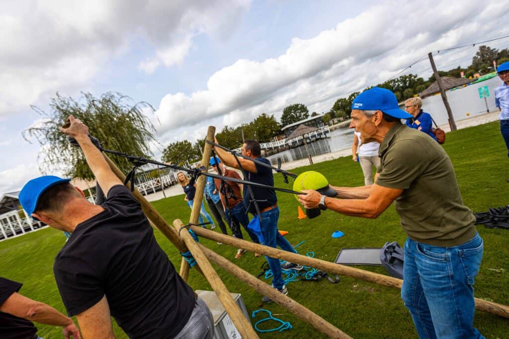 Deelnemers doen mee aan de katapult challenge tijdens een teambuildingactiviteit van Group Events bij Beachclub Degreez in Limburg.