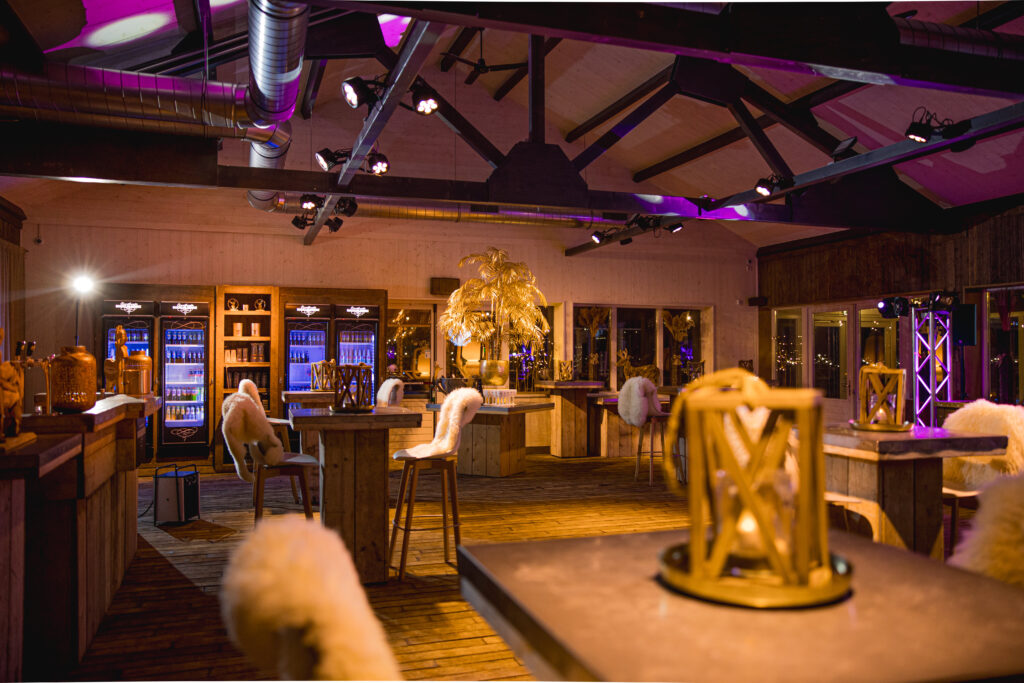 Sfeervolle winterse eventruimte met statafels, zachte vachten en warme verlichting bij Beachclub Degreez.
