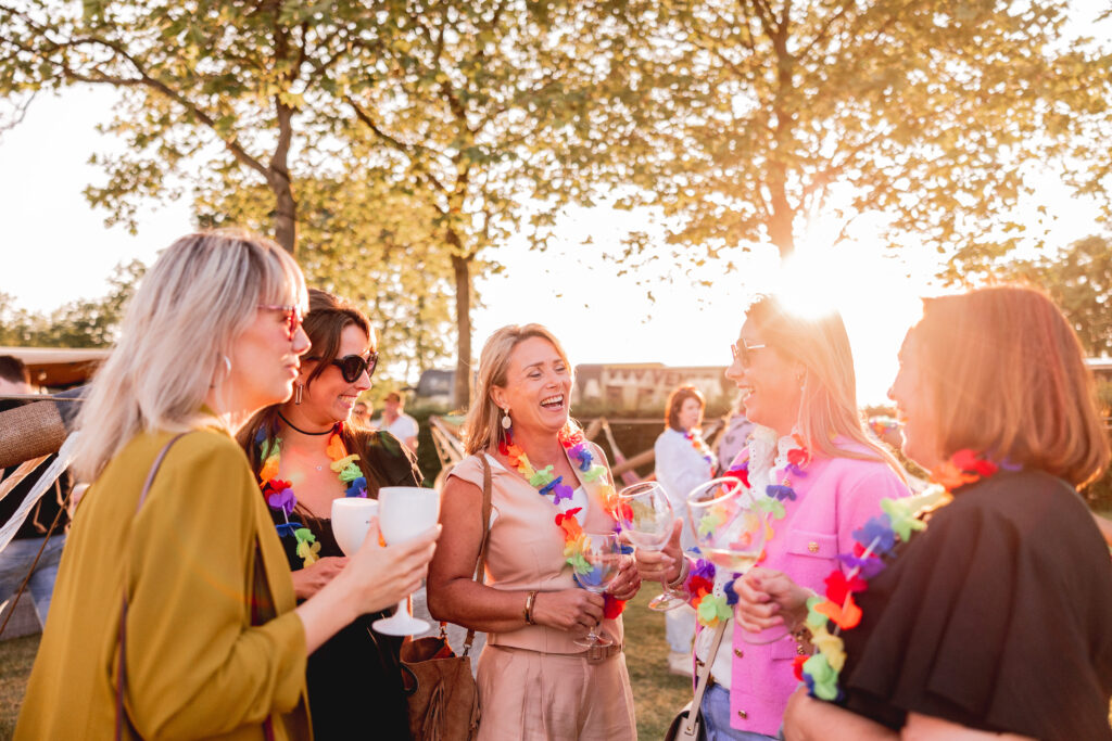Gasten genieten samen van een zomers bedrijfsfestival bij Beachclub Degreez, eventlocatie aan het water met ontspannen sfeer en persoonlijke beleving.