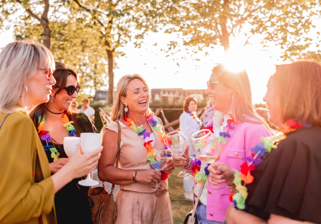 Gasten genieten samen van een zomers bedrijfsfestival bij Beachclub Degreez, eventlocatie aan het water met ontspannen sfeer en persoonlijke beleving.