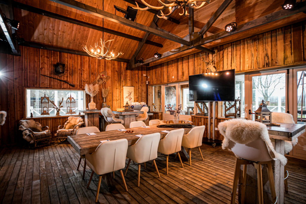 Sfeervolle lodge bij Beachclub Degreez ingericht als indoor eventruimte met lange tafel en warme winterse uitstraling.
