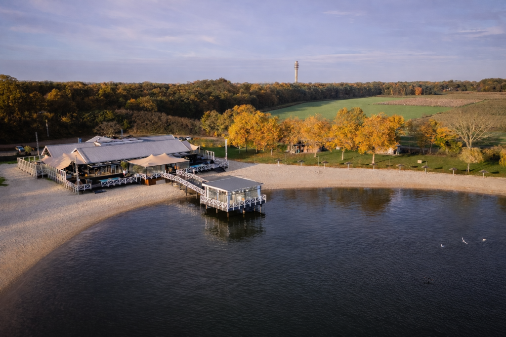 Panoramisch overzicht van Beachclub Degreez, gelegen aan het water en omringd door natuur.