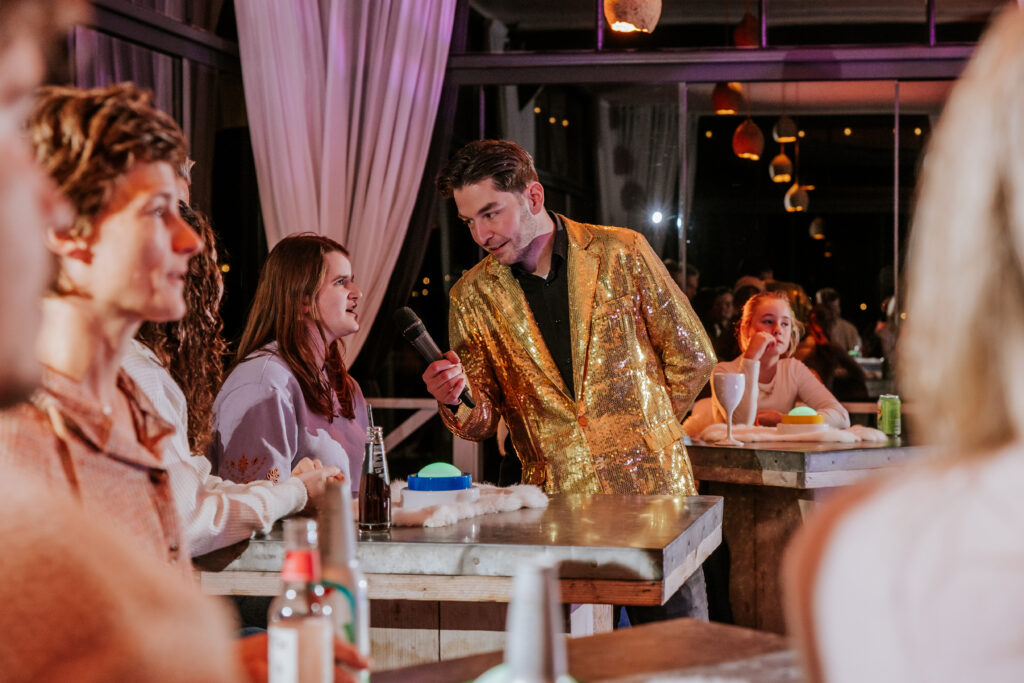 Deelnemers doen mee aan een interactieve quiz tijdens een indoor activiteit bij een zakelijk event bij Beachclub Degreez.